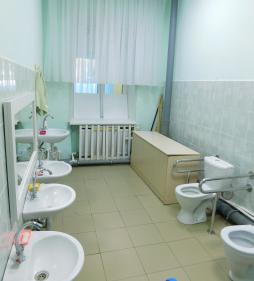 Туалетная комната оборудованная унитазом с поручнями