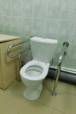 Туалетная комната оборудованная унитазом с поручнями
